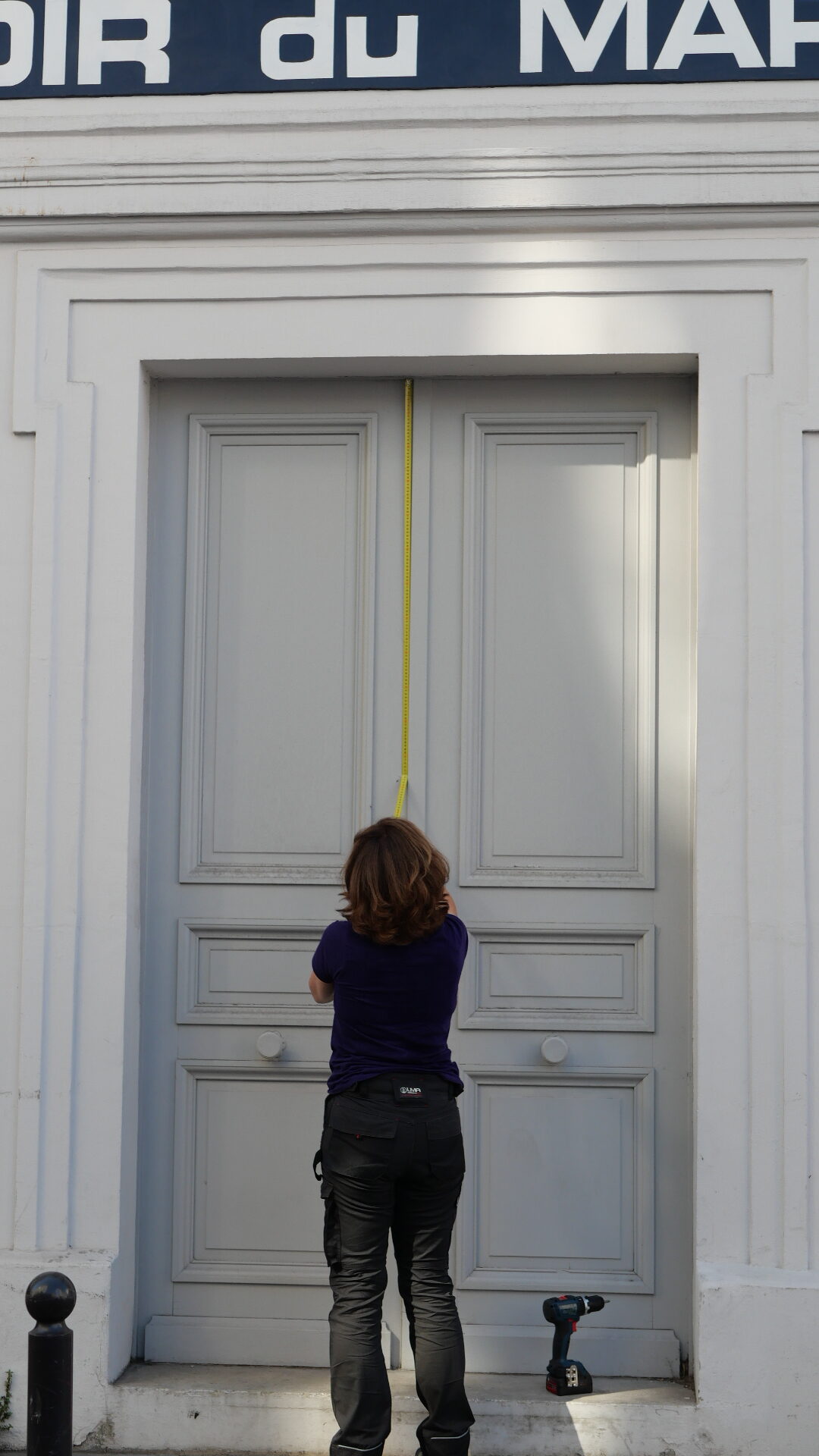 Christèle prenant les mesures d'une porte